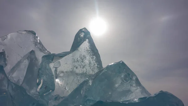 透明的绿松石冰在多云的天空中飘扬 奇形怪状的轮廓 边缘闪烁着阳光 左下角 复制空间 贝加尔湖 — 图库照片