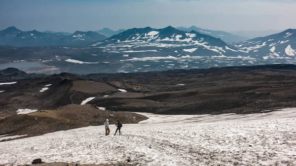 Upptinad Snö Täcker Bergssluttningen Två Personer Står Den Och Vilar — Stockfoto