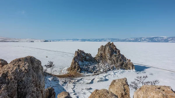 Two Headed Rock Devoid Vegetation Rises Frozen Lake Tiny Silhouettes — Stock Photo, Image