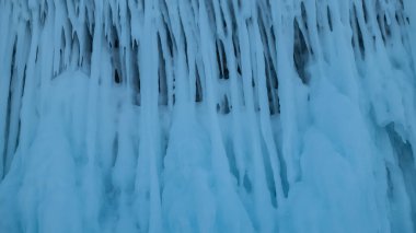 Süslü, uzun buz saçakları bir model oluşturuyor. Yakın plan. Tam ekran. Ayrıntılar. Baykal Gölü 'nün muhteşem buzu.