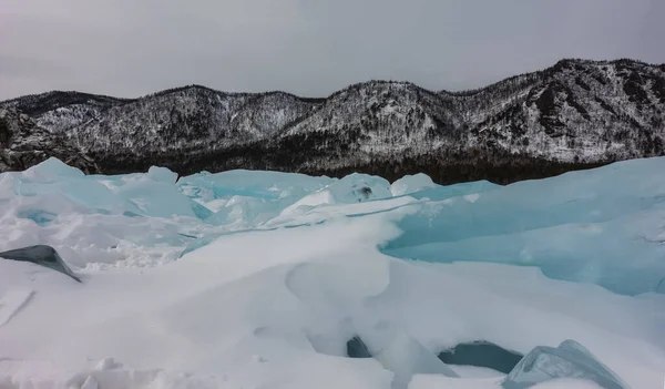 청록색 얼음덩어리는 눈으로 클로즈업 구름낀 하늘을 배경으로 바이칼호 — 스톡 사진