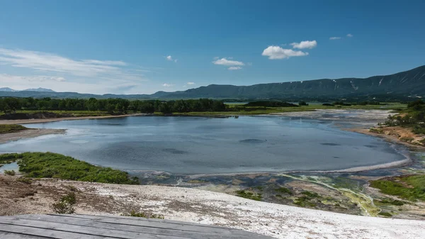 一座已灭绝火山火山口的蓝湖 由于嗜热微生物和藻类 沿海水域呈黄绿色 一座高耸于天空的山脉 堪察加半岛Uzon — 图库照片