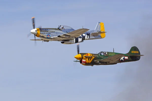 Винтажные самолёты P-51 Mustang и P-40 Warhawk, летящие вместе в строю на авиасалоне — стоковое фото