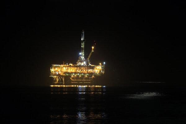 Oil rig platform at night along California coast