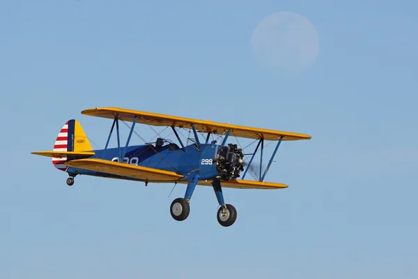 Bi-plane Oldtimer-Flugzeug fliegt unter dem Mond bei 2015 Flugzeuge of Fame Airshow — Stockfoto