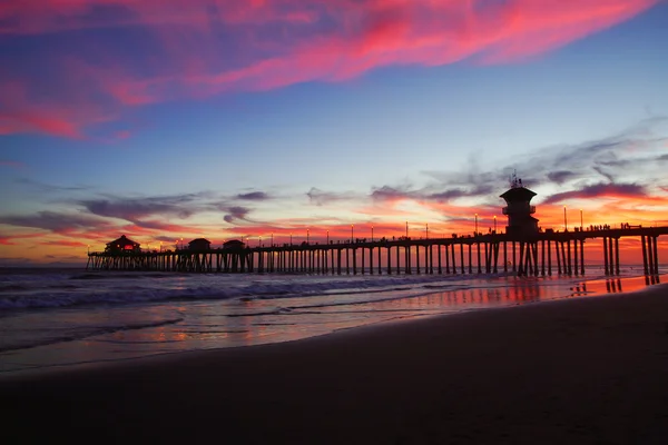 Cais de praia na Califórnia ao pôr do sol com nuvens no céu — Fotografia de Stock