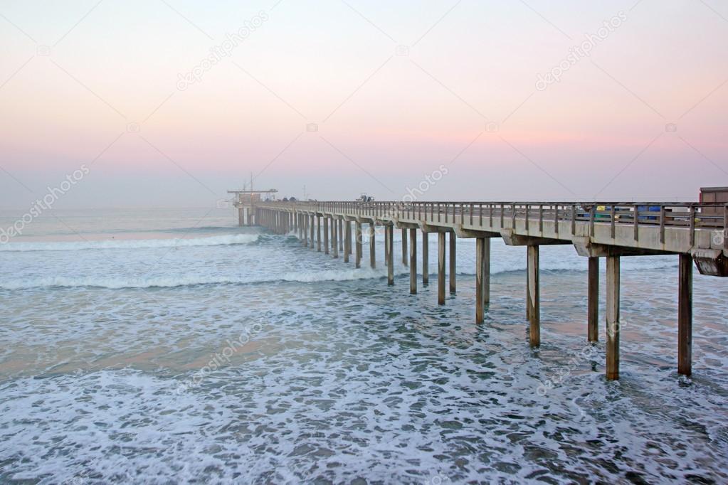 Beach pier sunrise during winter foggy morning at La Jolla, San Diego, California