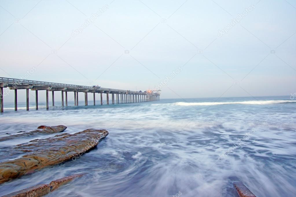 Beach pier sunrise during winter foggy morning at La Jolla, San Diego, California