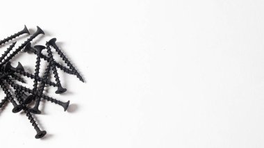 Beyaz arka plan pankartıyla kendini kesen yazılar. İnşaat aletleri, bağlanmak için kendi kendine dokunan vidalar. Siyah vida donanımı