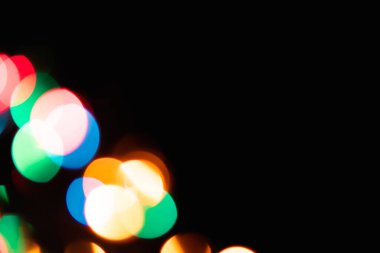 Kopyalama metni için odası olan siyah bir arkaplanda çok renkli parlaklıklar var. Şenlikli Yeni Yıl geçmişi.