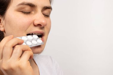 Bir adam ilaç hapı yutuyor. Belirtiler olmadan antibiyotik alma sorunu. Eczanenin yardımıyla tıptaki hastalıkların tedavisi