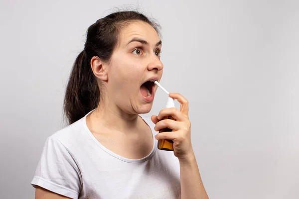 喉や咳の痛みを治療するために口の中でスプレー薬 — ストック写真