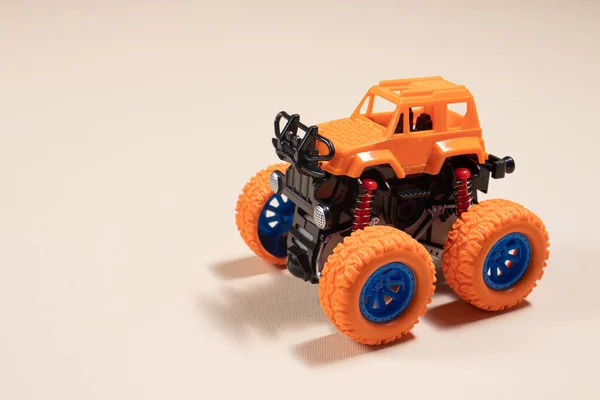 テキストのための場所とベージュの背景に子供のおもちゃのジープモンスタートラック 男の子の車 おもちゃ店 — ストック写真