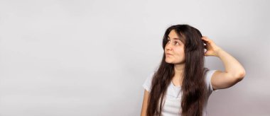 Kız başını kaşıdı ve maaştan önce parayı nereye götüreceğini düşündü. Kredi ve kredi parası, mesaj için yeri olan bir pankart. Aile bütçesi planlaması, para sorunları.