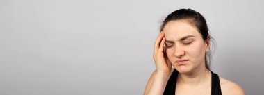 Yorgun kadın elini başının üzerinde tutuyor. Parasızlık, düşük ücretler ve işte sorunlar. Stres ve baş ağrısı