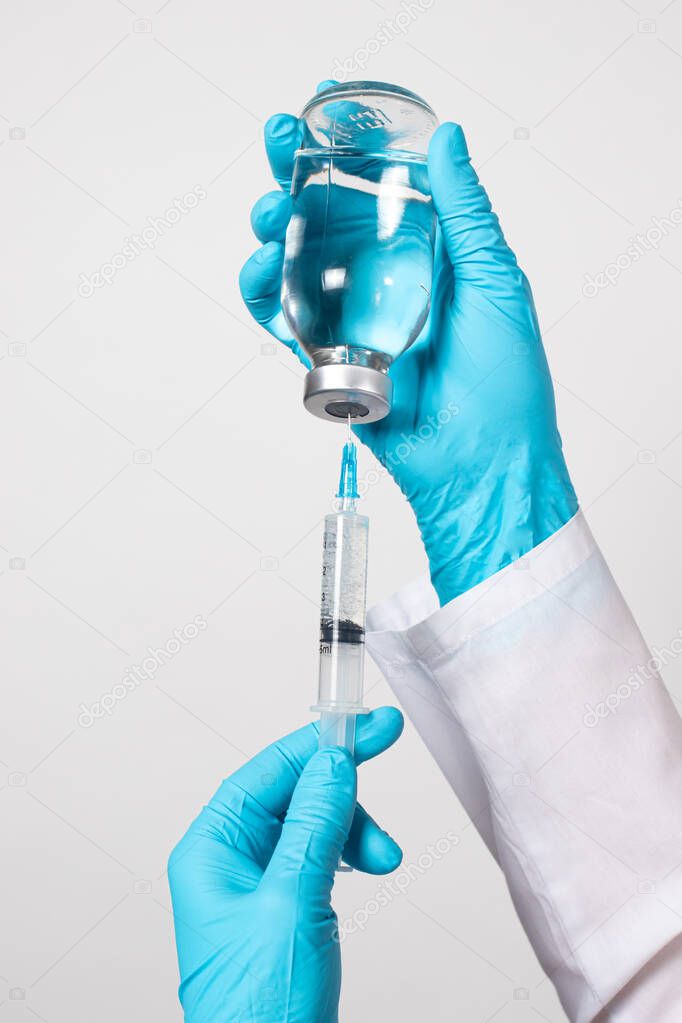 The nurse collects the saline solution of sodium chloride from the bottle into the syringe. Antibiotic breeding, vaccination, prevention and treatment of diseases.