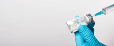 Eldivenli doktor bir kavanoz antibiyotiğe şırınga yoluyla tuz solüsyonu enjekte ediyor. Eczacılık, eczacılık ve tıbbi laboratuvar için metin yeri olan pankart.