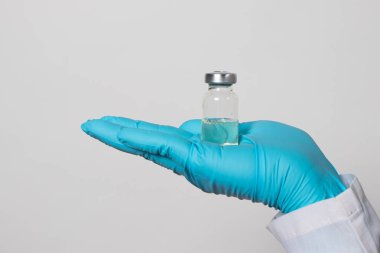 Bir doktor ya da laboratuvar teknisyeni bir aşı şişesi taşıyor. Tüberküloz, kuduz, tetanos ve diğer bulaşıcı hastalıklara karşı aşı. Kızamık, Rubella, Çocuk felci, Önleme.