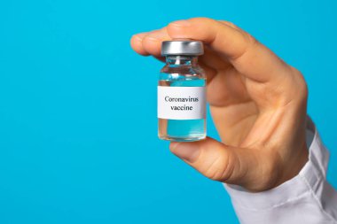 Bir doktor ya da laboratuvar teknisyeni, hastalıklara karşı aşısı olan bir test tüpü tutuyor. Covid-19 koronavirüse karşı aşı. Dünyada salgın hastalık, aşının icadı gibi. Sancak metin yeri