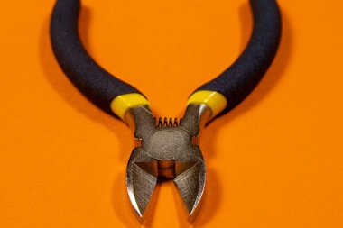 Elektrikçi için, kablo, kablo ve kablo kesmek için turuncu arka plan aracındaki meme uçları. İğne burun pensesi..