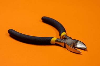 Elektrikçi için, kablo, kablo ve kablo kesmek için turuncu arka plan aracındaki meme uçları. İğne burun pensesi..