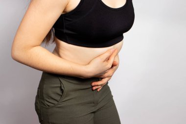 A woman's stomach hurts. Abdominal pain due to gastritis, stomach ulcers and Crohn's disease. Gastroenteritis, diarrhea or constipation. Nausea and vomiting after poisoning, toxicity pregnant clipart