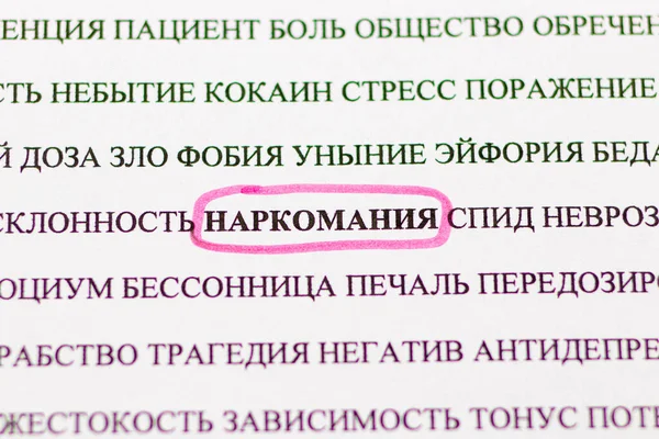 Rus gazetesinde pembe kalemle "Bağımlılık" sözcüğünün altını çizmek, büyüteçle üstten bakmak. Kötü alışkanlıklar, uyuşturucu bağımlılığı — Stok fotoğraf