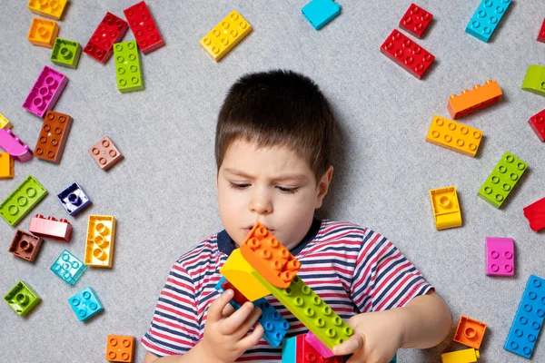 Chlapec Roky Hraje Multi Barevné Kostky Bloku Návrháře Šedém Pozadí — Stock fotografie