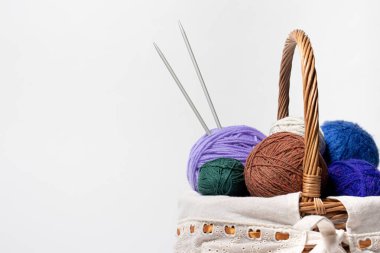 Örgü örmek ya da örgü örmek için renkli iplik yumaklarıyla dolu bir sepet. Hobiler ve iğne işiyle eğlence. Metin kopyalama alanı olan beyaz arkaplanda.