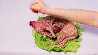 Aşçı tavşanı terbiye eder, limon suyuyla tavşan eti döker, limonu sıkar. Pişirmek için yağsız et pişirmek.