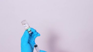 Bir doktor ya da laboratuvar teknisyeni kabakulak aşısı yapar ve ilacı beyaz arka planda bir şırıngada alır. Sağlık hizmetlerinde aşı kavramı
