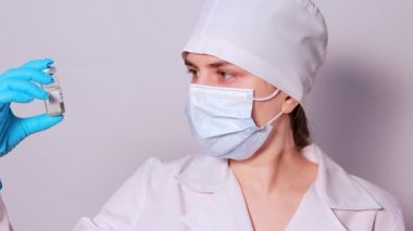 Bir doktor ya da laboratuvar teknisyeni kabakulak aşısı yapar ve ilacı beyaz arka planda bir şırıngada alır. Sağlık hizmetlerinde aşı kavramı