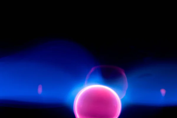 Plasma electric ball lightning lamp. Fascinating space video, close-up of electrical discharges with blue flames on a dark background.