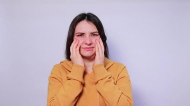 Kadın ellerini yüzünde tutuyor. Sinüzit, sinüs iltihabı, sinüzit, antrit, baş ağrısı. Tıp ve otolaringoloji. Trigeminal nevralji, sinir iltihabı ve sinir iltihabı, şiddetli.
