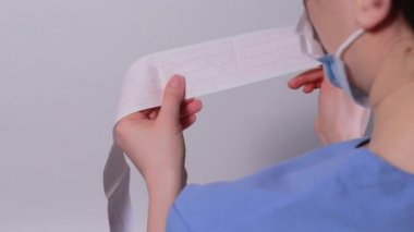 Kardiyolog akut miyokardiyal enfarktüsü olan bir hastanın elektrokardiyogramını gösteriyor. Kalp ve kardiyovasküler hastalıklar, kardiyoloji ve kardiyografi