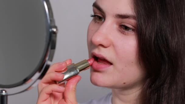 美しいブルネットの女性は鏡の前で口紅で彼女の唇を染めます 自家製のシンプルな化粧品 — ストック動画