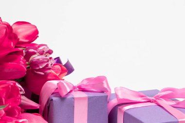 Laleler ve eflatun hediye kutuları. Beyaz arka planda mesajlaşmak için bir yer. Yazı için bayram dikey kartı