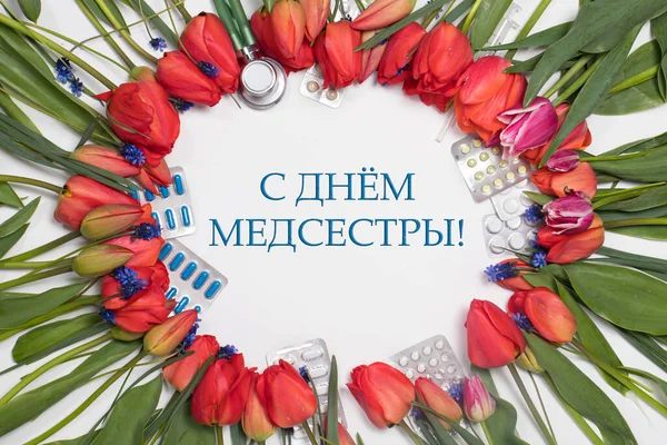 Flowers, phonendoscope and tablets - a flower frame with inscription in Russian Happy Nurse\'s Day on white