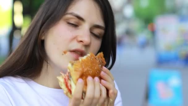 Brünette Frau Isst Auf Der Straße Einen Burger Völlerei Kalorienüberschuss — Stockvideo