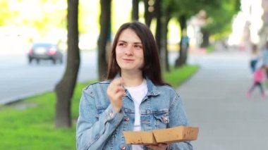 Patates kızartması yiyen güzel bir kadın. Şehirdeki caddelerde fast food, işe ya da okula giderken lezzetli öğle yemeği..