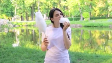 Hayranlık duyan esmer kız bir parça pamuk şekeri yırtıp atıyor. Tatlı yiyeceklerden neşe ve mutluluk dolu gözler.