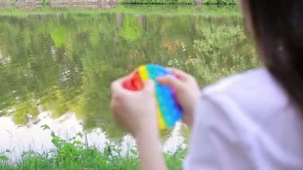 Farbige Trendige Spielzeug Pop Den Händen Eines Erwachsenen Auf Dem — Stockvideo