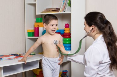 Steteskoplu bir çocuğun pediatrik muayenesi. Küçük çocuk ve çocuk doktoru..