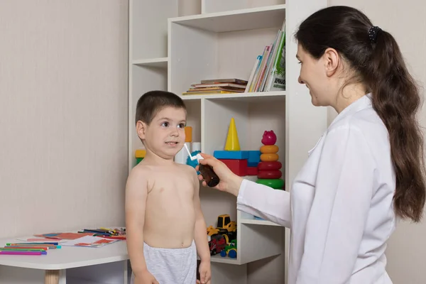 Un pediatra y un niño de 3-4 años. Aerosol nasal, tratamiento de rinitis, secreción nasal. — Foto de Stock