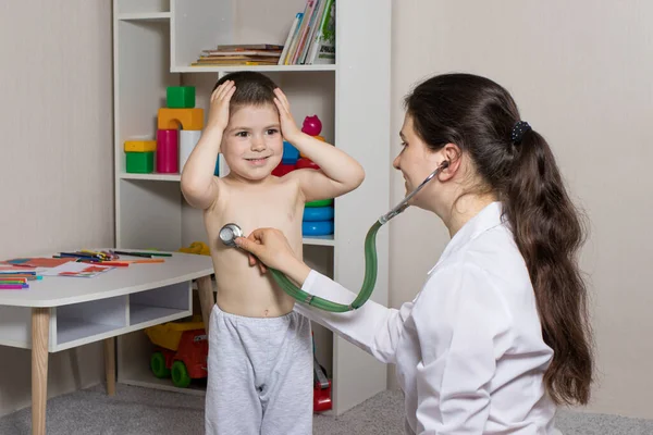 De kinderarts zal auscultiseren de longen en het hart van een kleine jongen 3-4 jaar oud. Pediatrie, huisartsenafspraak. — Stockfoto