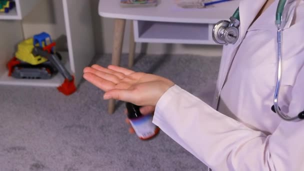 Een kinderarts of verpleegkundige in een wit uniform giet vitamine D uit een pot. Bioadditieven voor kinderen. — Stockvideo