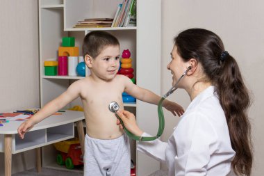 Steteskoplu bir çocuğun pediatrik muayenesi. Küçük çocuk ve çocuk doktoru..