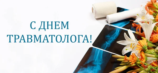 Menyambut kartu dengan bunga dan X-ray dan tulisan pada Rusia Pada hari traumatologist. — Stok Foto