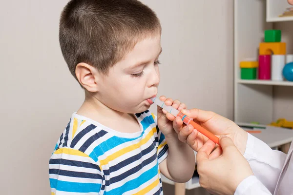 小児科医または看護師は測定注射器で子供のシロップを与えます。咳の治療,子供の温度.小児科の幼児および未就学児のためのパラセタモールまたはイブプロフェン — ストック写真