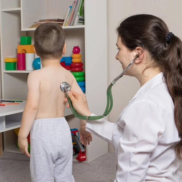 De kinderarts onderzoekt de longen en het hart van een slavin met behulp van een fonendoscoop. Berekening, diagnose van longontsteking bij kinderen — Stockfoto